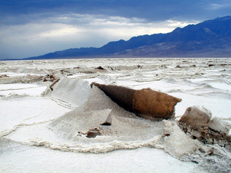Expansive white salt flats of Badwater Basin with mountains in the background, Death Valley National Park