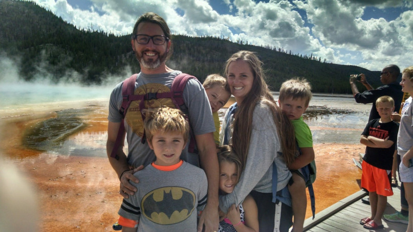Family watching old faithful yellowstone Family watching Old Faithful geyser eruption in Yellowstone National Park