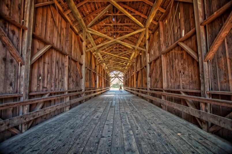 Tall wooden covered bridge among redwood trees in California