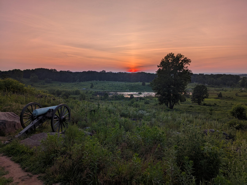 Gettysburg battlefield at sunset Rolling fields with monuments and cannons at Gettysburg National Military Park