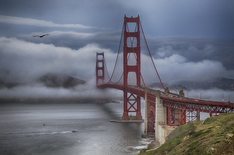 Golden Gate Bridge partially covered in fog with San Francisco Bay views