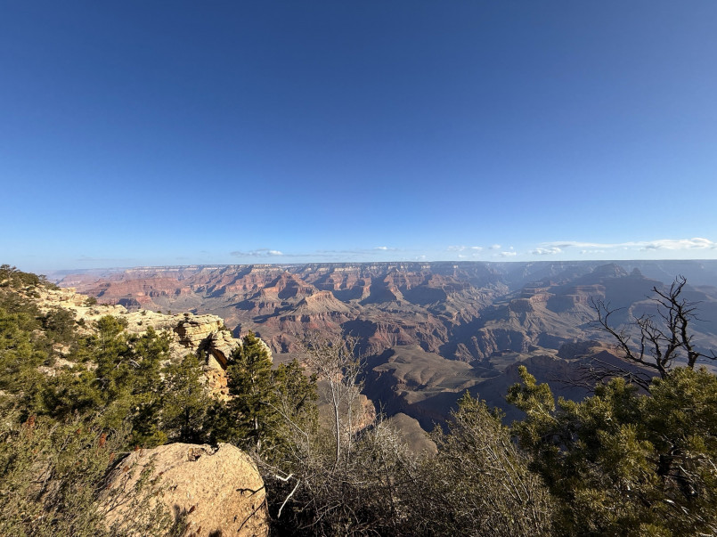 Grand canyon south rim trail view Hikers enjoying a panoramic view from the South Rim Trail of the Grand Canyon with colorful geological layers visible