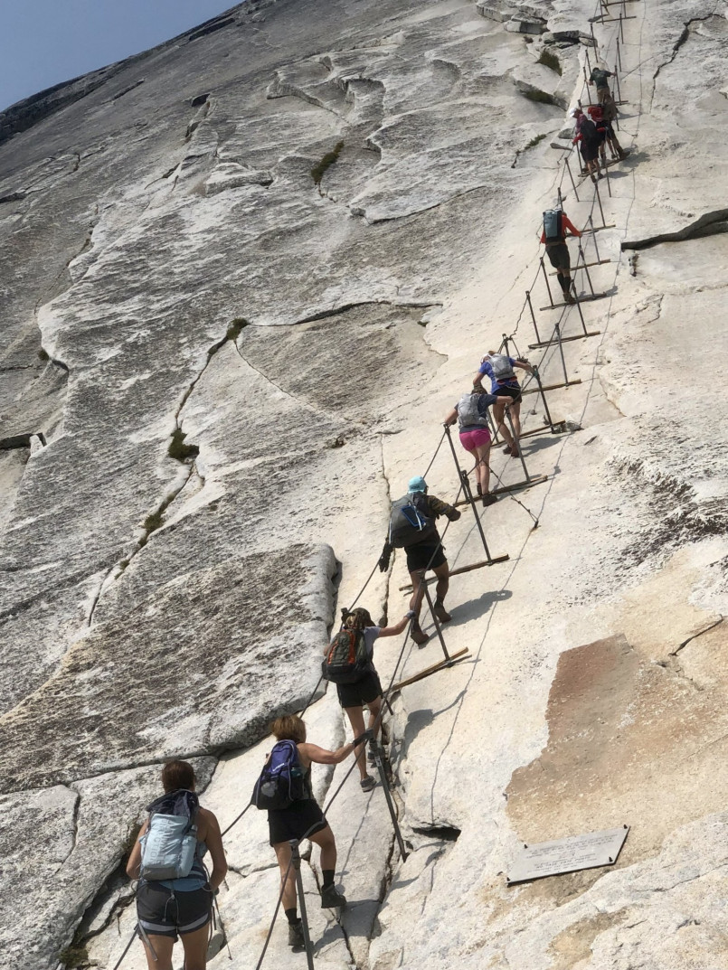 Hikers ascending the cables on Half Dome in Yosemite National Park