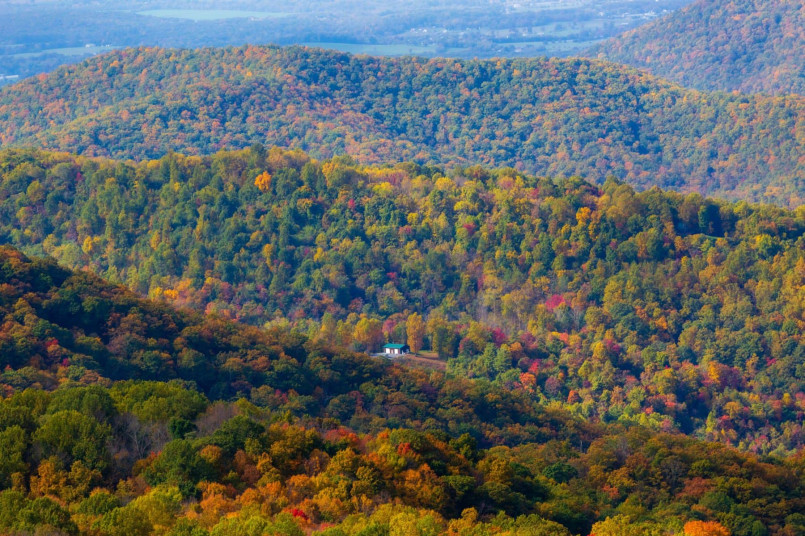 Hikers on ridgeline trail with colorful fall foliage views in Shenandoah National Park