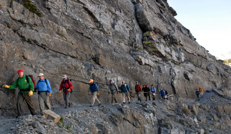 Hikers on the Highline Trail with sweeping mountain views in Glacier National Park