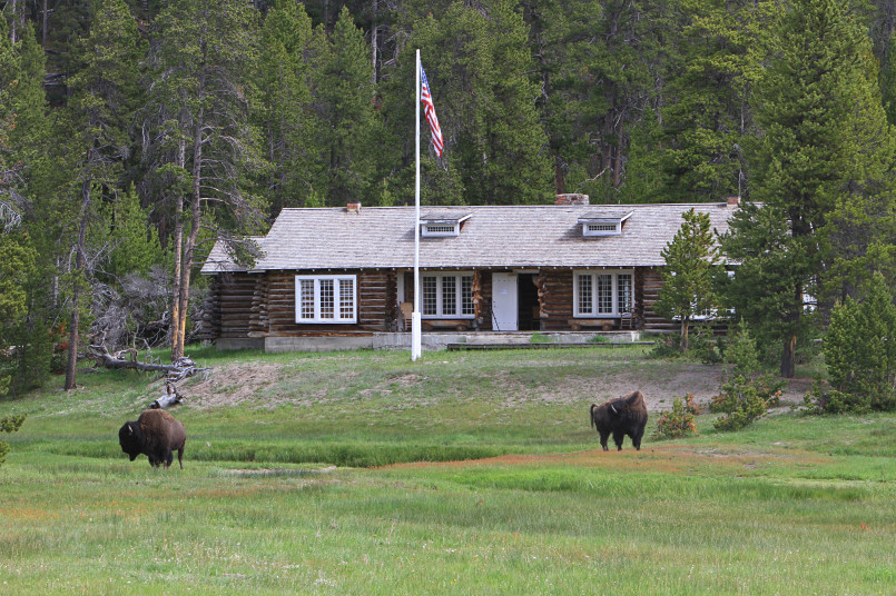 Preserved historic log cabin ranger station with antique park service sign