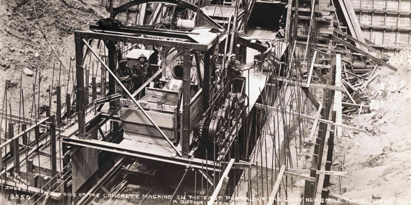 Historical photo of workers constructing Hoover Dam with scaffolding
