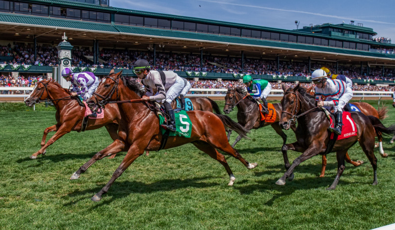 Thoroughbreds racing on the track at Keeneland Race Course with its distinctive grandstand