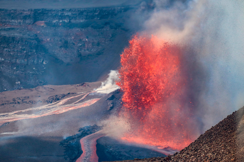 Kilauea volcano eruption Hawaii Red-hot lava flowing from Kilauea volcano at night with steam rising