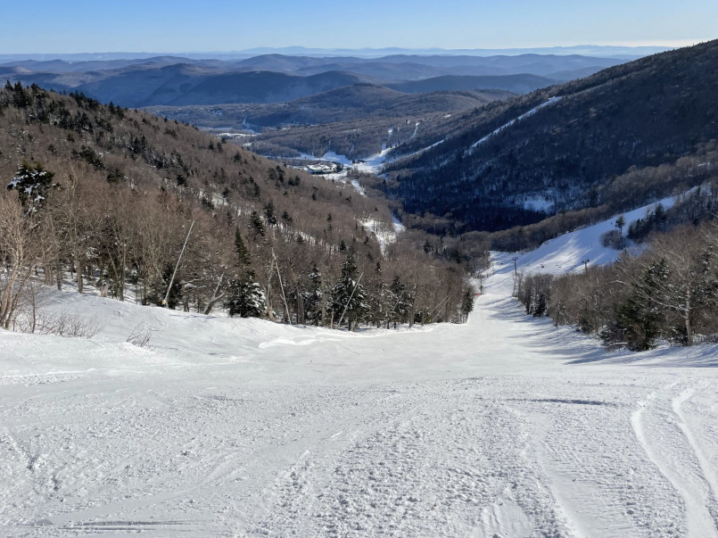 Skiers on slopes at Killington Resort with Vermont's Green Mountains in background
