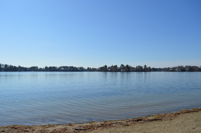 Vibrant autumn foliage surrounding Lake Chargoggagoggmanchauggagoggchaubunagungamaugg with red and orange trees reflected in the water