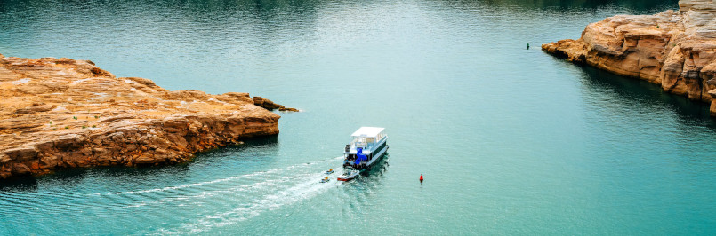 Colorful houseboats anchored in turquoise waters of Lake Powell with red rock formations