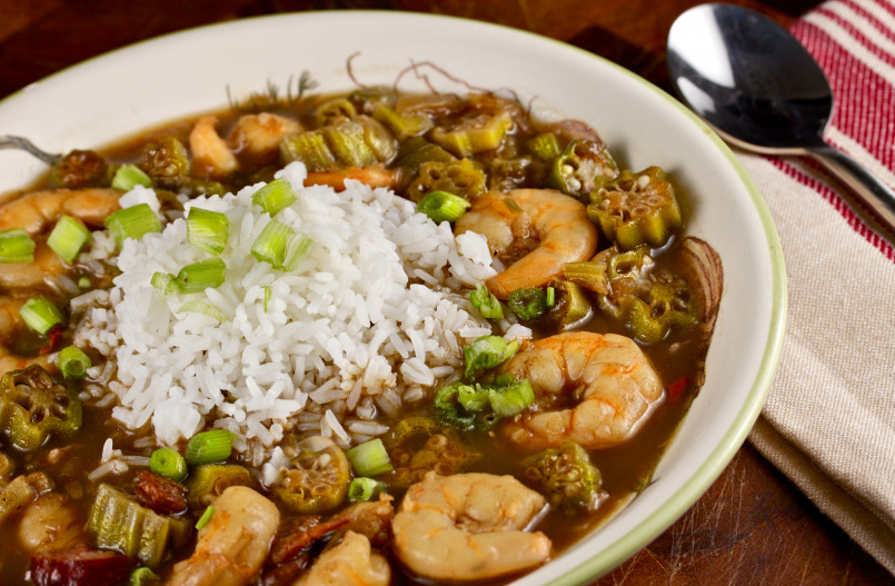 Bowl of dark rich gumbo filled with seafood and served over white rice
