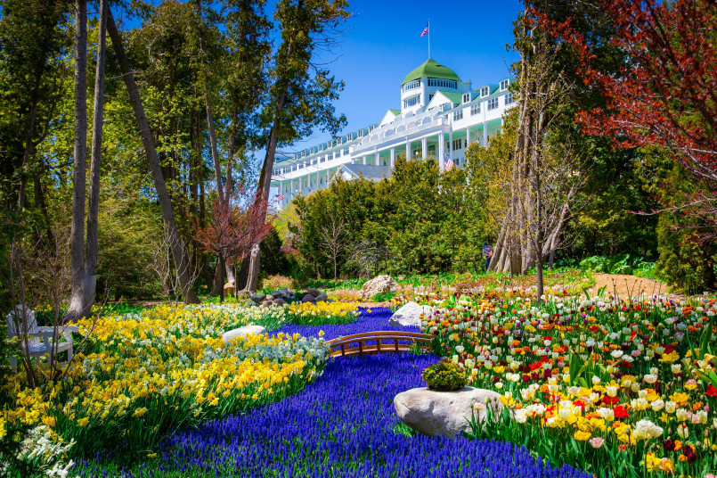 White Grand Hotel with its long front porch and Victorian architecture surrounded by green gardens