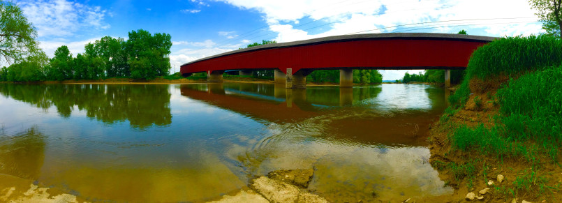 Weathered covered bridge over a wide river in rural Indiana