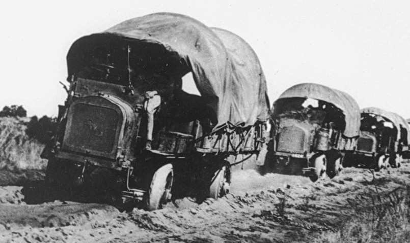Military convoy of vehicles on dirt road in 1919