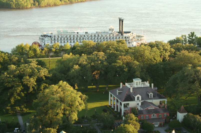 Historic mansion along River Road with columns and oak trees