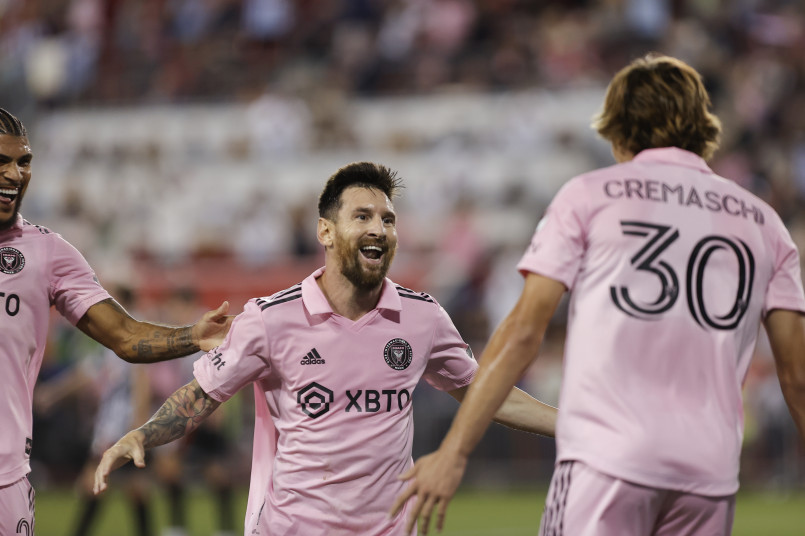Major League Soccer players celebrating a goal with excited fans in the background