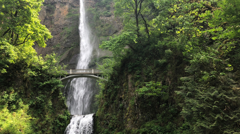 Multnomah Falls with historic stone bridge visible from the Columbia River Highway