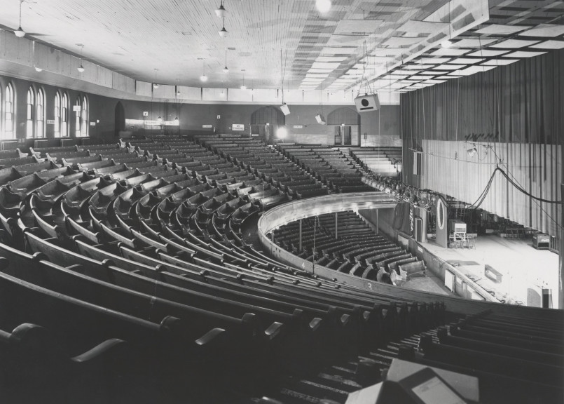 Nashville Ryman Auditorium interior Interior of the historic Ryman Auditorium with wooden pews and colorful stained glass windows