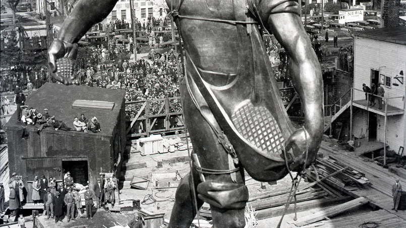 Nebraska State Capitol with its 400-foot tower and The Sower bronze statue on top against a blue sky