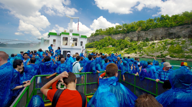 Tourists on the Maid of the Mist boat tour wearing blue ponchos as they approach the powerful spray of Niagara Falls