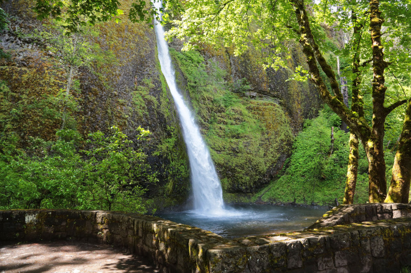 Hiker on trail beside Multnomah Falls in Oregon's Columbia River Gorge