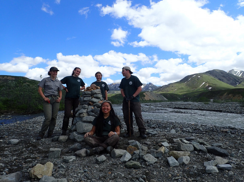 Park rangers monitoring wildlife with Denali mountain range in background