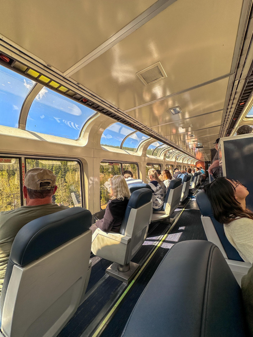 Passengers enjoying panoramic views from the observation car of the California Zephyr as it passes through Colorado's Rocky Mountains