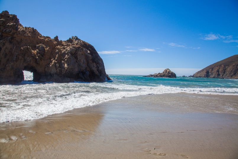 Keyhole Rock at Pfeiffer Beach with purple-tinted sand and sunset light