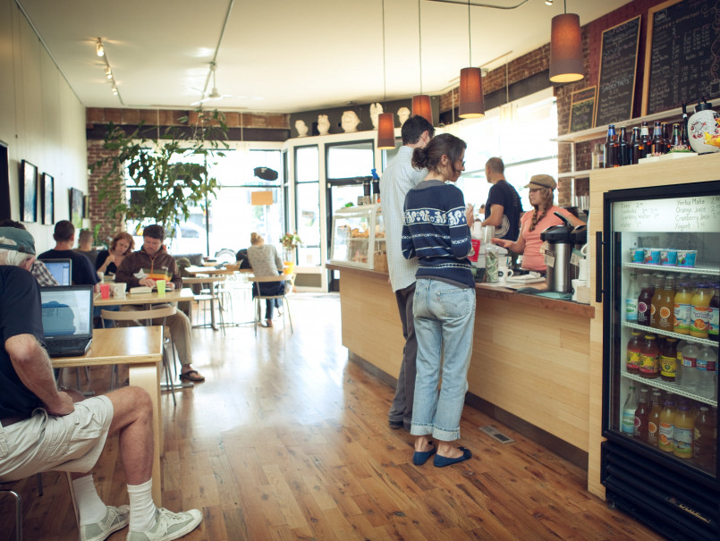 Portland oregon coffee shop interior, specialty coffee A busy Portland coffee shop with wooden interior, plants, and customers enjoying pour-over coffee