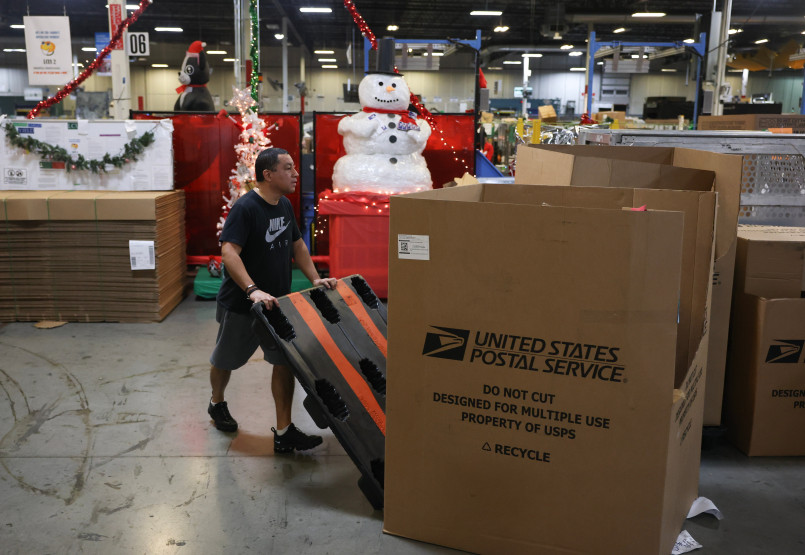 Postal worker delivering packages holiday season Mail carrier with arms full of packages during busy delivery day