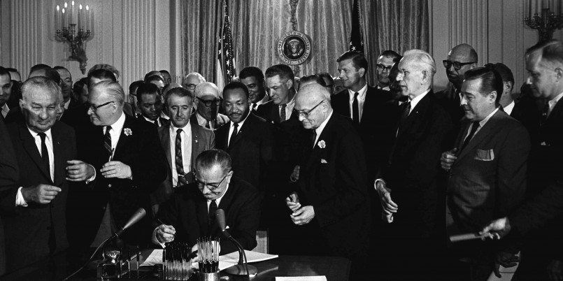 President Lyndon Johnson signing the Civil Rights Act of 1964 surrounded by legislators and civil rights leaders