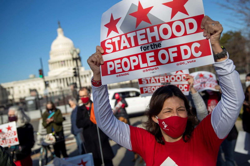 DC statehood protest march Capitol Hill Protesters marching for DC statehood holding signs near the US Capitol