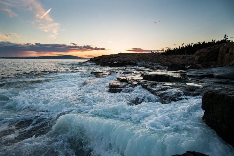 Rocky coastline of Acadia National Park with lighthouse in Maine