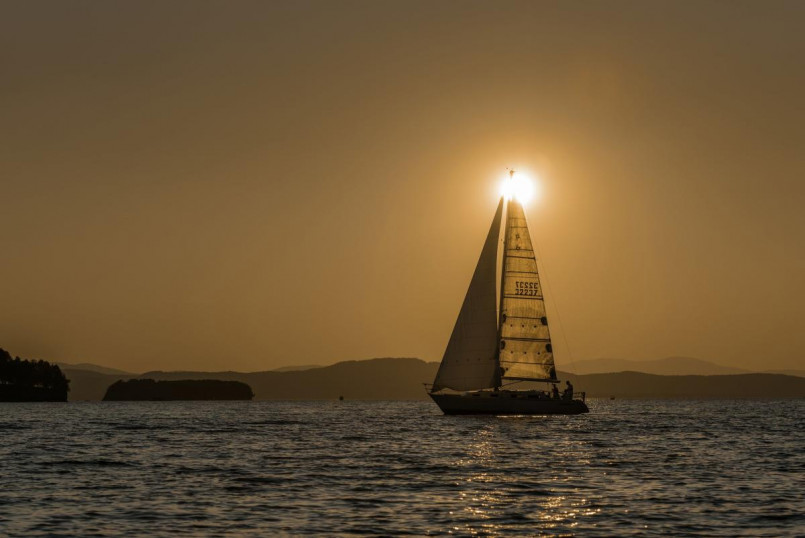 Lake Champlain Vermont sunset sailboat Sailboat on Lake Champlain at sunset with Adirondack Mountains in background