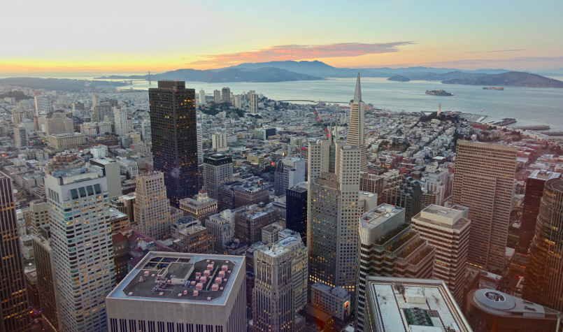 Salesforce Tower with its illuminated crown against a sunset sky over San Francisco