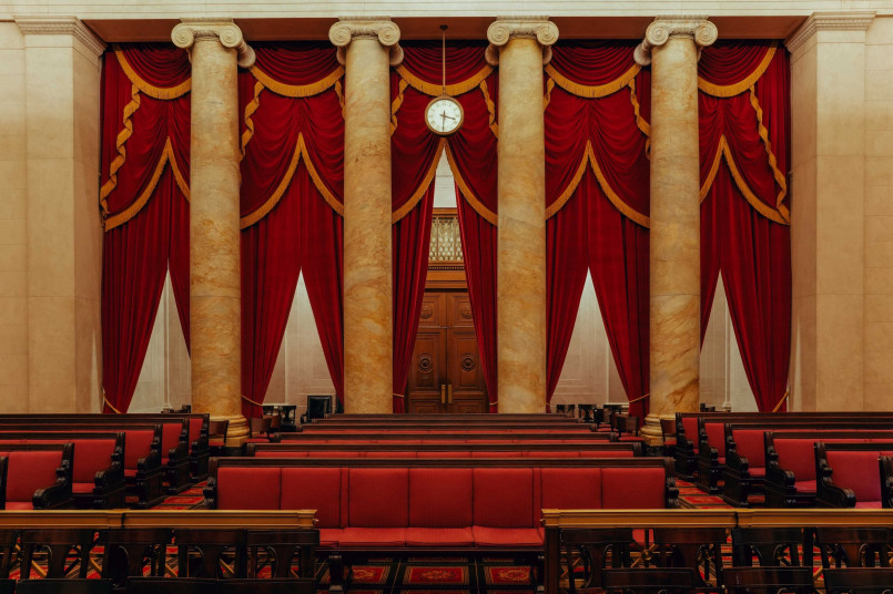 The ornate interior courtroom of the Supreme Court with red velvet curtains and judicial bench