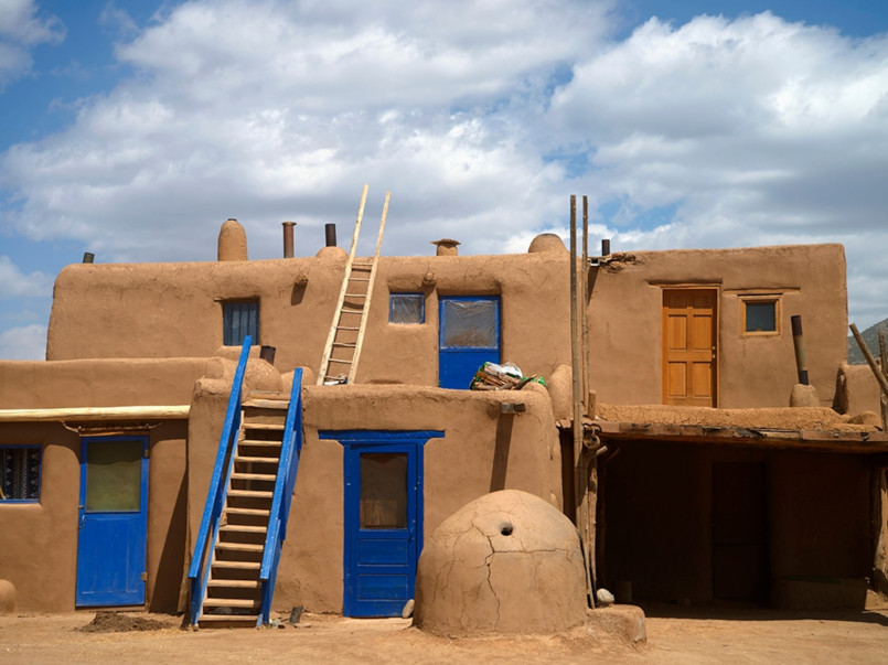 Taos new mexico pueblo adobe buildings Traditional adobe buildings in Taos with mountain backdrop