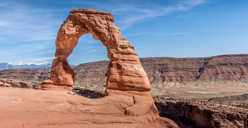 The iconic Delicate Arch standing against a blue sky background in Arches National Park