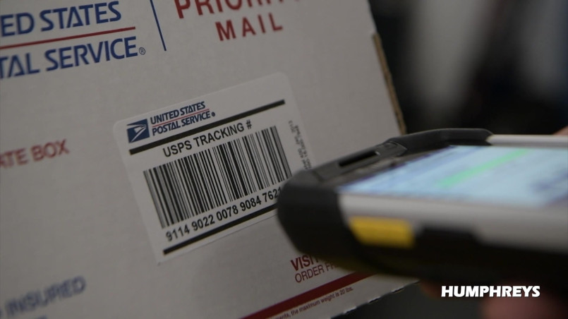Usps tracking technology barcode scanner Postal worker scanning package barcode with handheld device