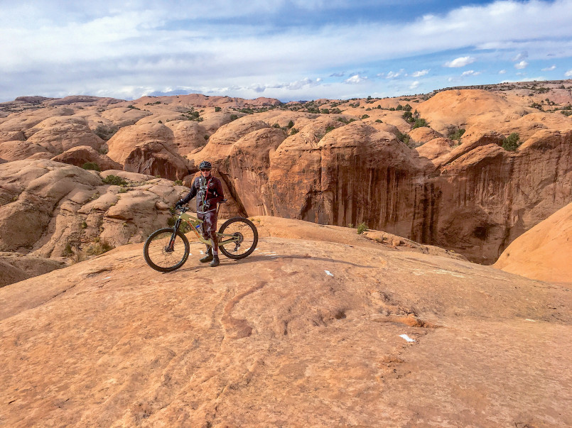 Mountain biker on Slickrock Trail in Moab with red rock formations in the background