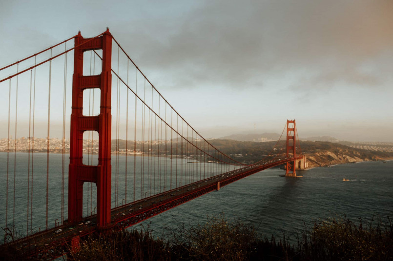 Golden Gate Bridge San Francisco fog view View of the Golden Gate Bridge with fog rolling in, showing its distinctive orange-red towers rising above the mist