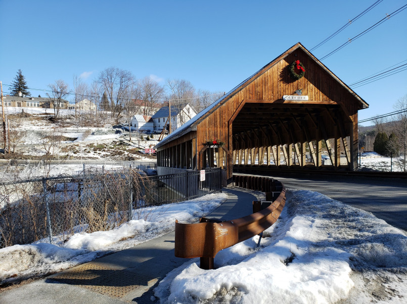 Woodstock Vermont winter covered bridge Snow-covered covered bridge in Woodstock decorated with evergreen garlands and Christmas lights