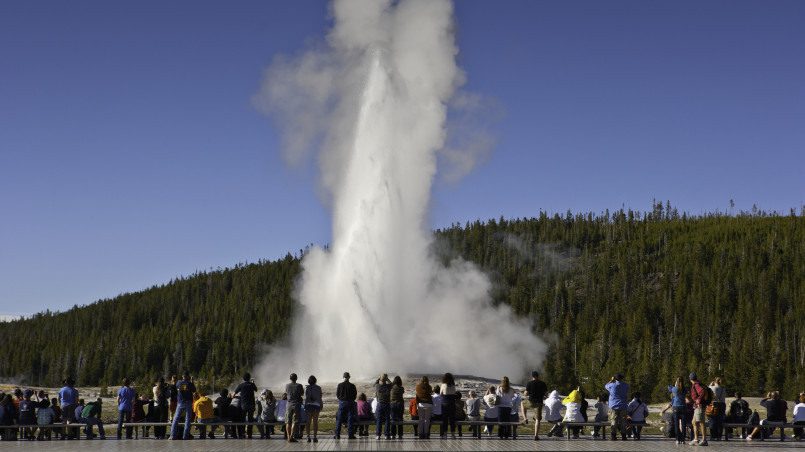 Tourists gathered to watch Old Faithful geyser erupting in Yellowstone National Park